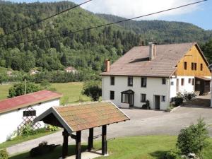 a large white house with a roof at Maison de Montagne à La Bresse, 2 Chambres, Confort et Activités, Garage, Wifi Inclus - FR-1-589-152 in La Bresse