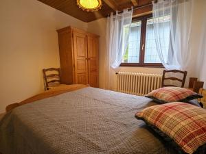um quarto com uma cama com duas almofadas e uma janela em Gîte La Bresse, 3 pièces, 4 personnes - FR-1-589-127 em La Bresse