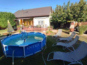 a large blue tub sitting in the yard with chairs at Holiday home in Siofok - Balaton 45811 in Siófok