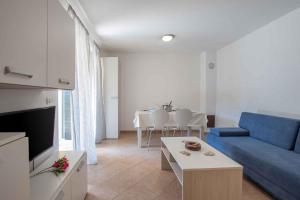 een woonkamer met een blauwe bank en een tafel bij Apartments in Umag - Istrien 26717 in Umag