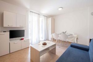 een woonkamer met een blauwe bank en een tafel bij Apartments in Umag - Istrien 26717 in Umag