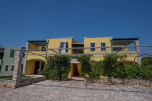 een geel huis met een balkon erboven bij Apartments in Umag - Istrien 26717 in Umag
