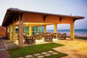 un patio con mesas y sillas y el océano en Dream Away Uruaú Beach Residences, en Beberibe