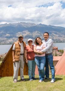 a group of people standing on top of a house at Glamping Campo Lago San Pablo in Otavalo
