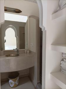 y baño con lavabo y espejo. en Riad Kamilyes, en Marrakech