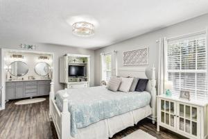 een witte slaapkamer met een bed en een televisie bij 3224 Birdseye Circle in Gulf Breeze