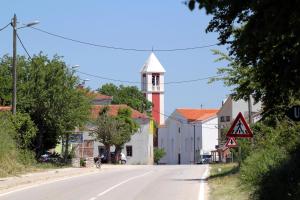 Gornji ZemunikにあるFamily friendly house with a swimming pool Zemunik Donji, Zadar - 21653の時計塔のある小さな町の空き道