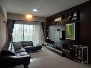 ein Wohnzimmer mit einem Ledersofa und einem TV in der Unterkunft K. Riverfront apartment in Ipoh
