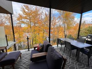 - un salon avec une table, des chaises et une grande fenêtre dans l'établissement Le Riverain - Condo neuf au bord de l'eau, à Shawinigan