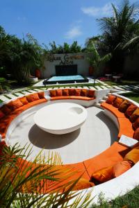 um pátio circular com uma mesa branca e cadeiras laranja em Lukas Garden Accra em Accra