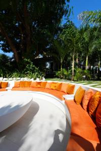 a bench with orange and white pillows on it at Lukas Garden Accra in Accra