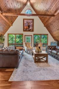 a living room with leather furniture and a wooden ceiling at Star Gazer Luxury A-Frame Wood Cabin. Near York/Harrisburg/Hershey/Lancaster in Goldsboro