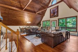 una sala de estar con muebles de cuero y techos de madera. en Star Gazer Luxury A-Frame Wood Cabin. Near York/Harrisburg/Hershey/Lancaster en Goldsboro