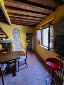 - un salon avec une table et une télévision dans l'établissement La Rocca Sovrana - Casa Vacanze, à Aramo