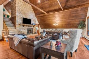 sala de estar con muebles de cuero y pared de piedra. en Star Gazer Luxury A-Frame Wood Cabin. Near York/Harrisburg/Hershey/Lancaster en Goldsboro