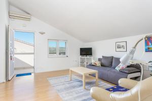 una sala de estar con un sofá y una mesa en Apartment Seget Vranjica 14409a, en Donji Seget