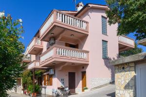 a pink building with balconies on it at Apartments by the sea Duga Luka - Prtlog, Labin - 2335 in Labin