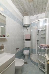 a bathroom with a toilet and a shower and a sink at Apartments by the sea Duga Luka - Prtlog, Labin - 2335 in Labin