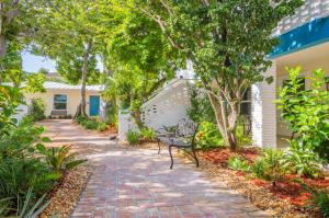 a brick walkway in front of a house with a bench at Seaside Villas in Fort Lauderdale