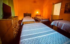 Habitación con 3 camas y TV de pantalla plana. en Residencial Italiana, en Los Andes
