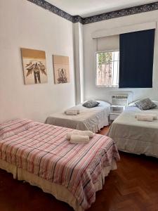 1 dormitorio con 2 camas y ventana en Ipanema 2 quartos à 3 quadras da praia com garagem, en Río de Janeiro