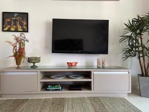 a white entertainment center with a flat screen tv on top at apartamento vista mar in Aquiraz
