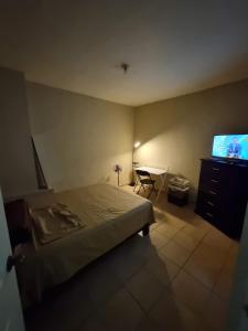 1 dormitorio con cama, mesa y TV en Departamento Victoria en Saltillo