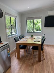 a dining room with a wooden table and chairs at Beechworth Lake Sambell Caravan Park in Beechworth
