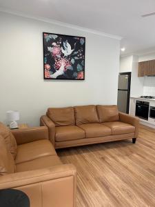 a living room with a couch and a kitchen at Beechworth Lake Sambell Caravan Park in Beechworth