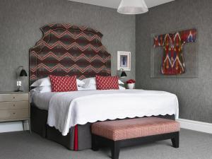 a bedroom with a bed, a dresser, and a lamp at The Soho Hotel, Firmdale Hotels in London