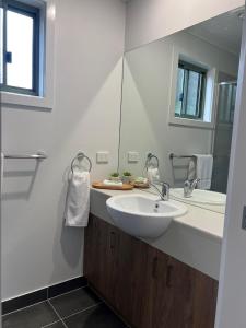 Baño blanco con lavabo y espejo en Beechworth Lake Sambell Caravan Park, en Beechworth