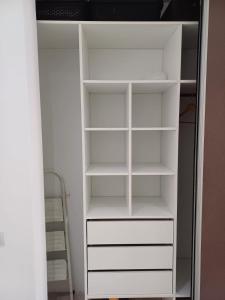 a white closet with white shelves and a ladder at Palmas de Recoleta in Buenos Aires