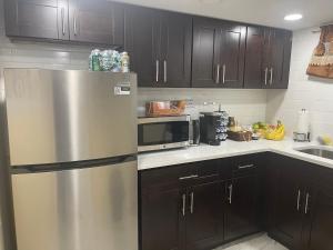 a kitchen with a stainless steel refrigerator and a microwave at A cool unique place from home in Elmont
