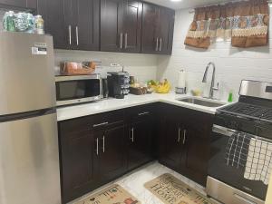 a kitchen with a refrigerator and a sink and a microwave at A cool unique place from home in Elmont