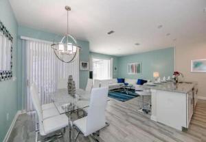 a dining room with a table and white chairs at Stunning Townhouses 5 Minutes away Disney! in Kissimmee