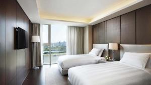 a hotel room with two beds and a window at LOTTE City Hotel Daejeon in Daejeon