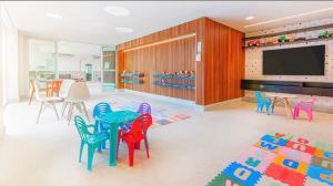 a room with colorful chairs and a table and a television at Apto Salinas Exclusive Resort, 2 quartos in Salinópolis
