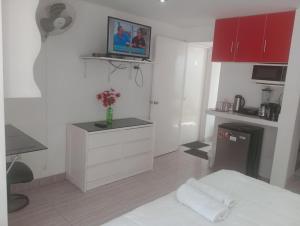 Habitación blanca con cama y TV en la pared en Monterrico Suites Hotel, en Lima
