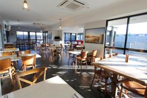 a restaurant with tables and chairs and windows at The Stirling Motel in Rockhampton