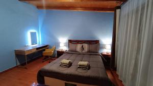 1 dormitorio con 1 cama grande y pared azul en Hostal Yurak en San Pedro de Atacama