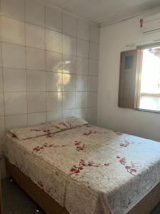 Un dormitorio con una cama con flores. en Casa Vermelha en Morro de São Paulo