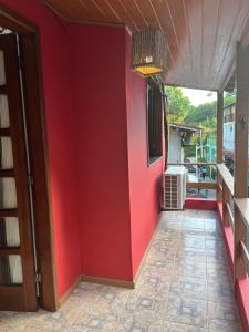 a room with a red wall and a doorway at Casa Vermelha in Morro de São Paulo
