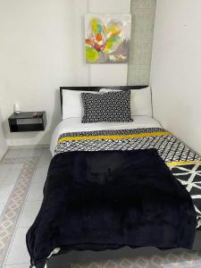 Un dormitorio con una cama con una manta negra. en APARTAESTUDIOS BOGOTÁ, en Bogotá