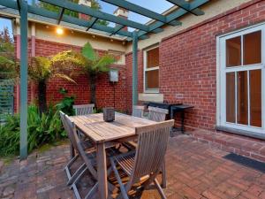a wooden table and chairs on a brick patio at Central Crisp in Albury