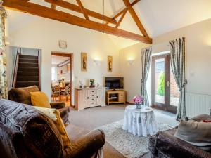 a living room with a couch and a tv at Pear Tree Cottage in Banham