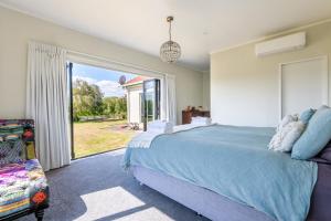 a bedroom with a bed and a large window at Big Inn Brunswick in Rotorua
