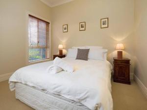 a bedroom with a large white bed and a window at 'Ampleforth East' in Albury