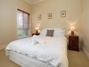 奥尔伯里'Ampleforth East'的卧室里有一张白色的大床和一扇窗户