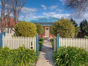 a white fence in front of a house at 'Ampleforth East' in Albury