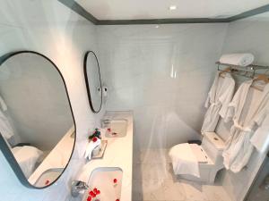 a bathroom with a mirror and a sink and a toilet at LuangPrabang Pearl Hotel in Luang Prabang